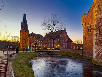 View in winter over a partially frozen moat at a castle converted into a Renaissance castle today
