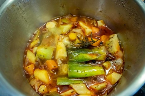 A vegetable stock is cooked, various vegetables are boiled with spices and herbs in water for a