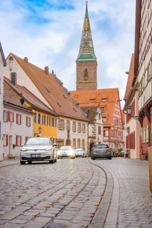 Historic old town with cobblestones and colorful houses, a church tower in the background, ID3,