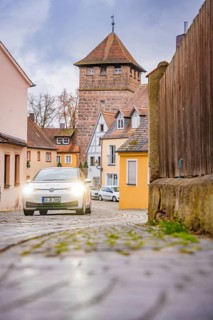 Scene in Altstadtgasse with cobblestones and a fortified tower, ID3, Deer E-Carsharing, Germany