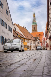 Paved alley in charming old town district with church tower, ID3, deer e-car sharing, Germany