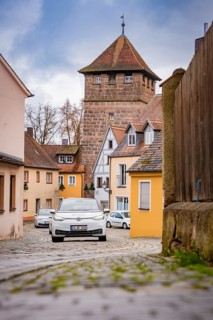 Narrow alley with cobblestones and old defensive towers in a village, ID3, deer e-car sharing,