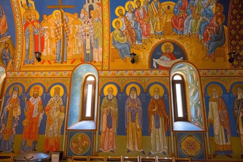 Orthodox church with glowing frescoes and saints, conveys a spiritual atmosphere, St. Barbara