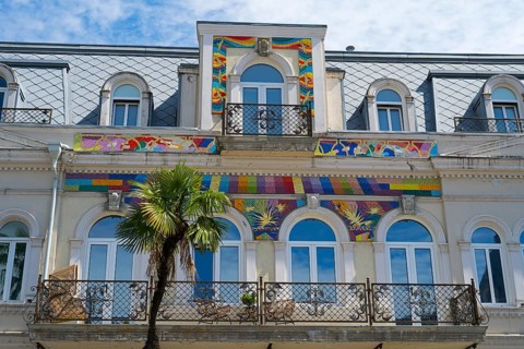 Detailed view of a building with colorful ornaments and palm trees in front of the balcony, Europe