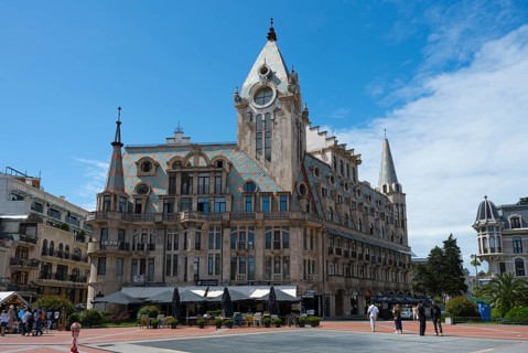Historic building with roof gables in a public square under clear sky, Europe Square, Batumi, Black