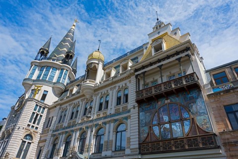 Magnificent building with decorated tower and detailed façade under blue sky, Astronomical Clock,