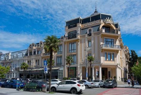 Elegant building with decorated facades and palm trees in front of a parking lot, Royal Casino and