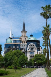 Historically inspired building with tower and palm trees, former registry office, now