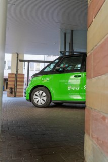 Green car in a covered area of a modern city, Deer E-Mobility Shuttle Service, Calw, Germany