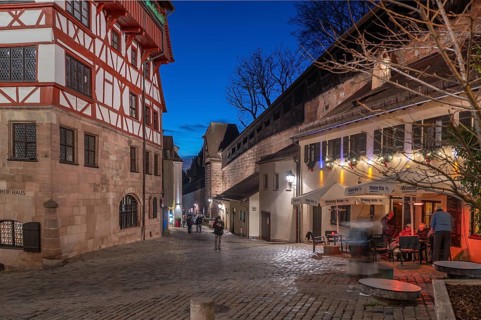 The old city wall with rampart, on the left the historic Dürerhaus, in evening lighting, Beim
