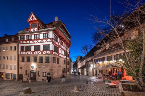 The historic Dürerhaus, on the right the old city wall with a rampart, in evening lighting, Beim