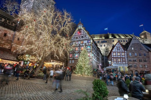 Illuminated trees with the historic Pilate House with advent calendar, in the evening lighting, the