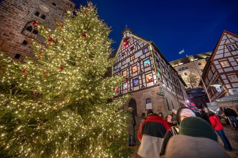 Illuminated Christmas tree with the historic Pilate House with advent calendar, in the evening