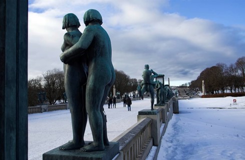 Sculptures on a snowy bridge, people walking, cold winter atmosphere, Vigeland sculpture park Oslo
