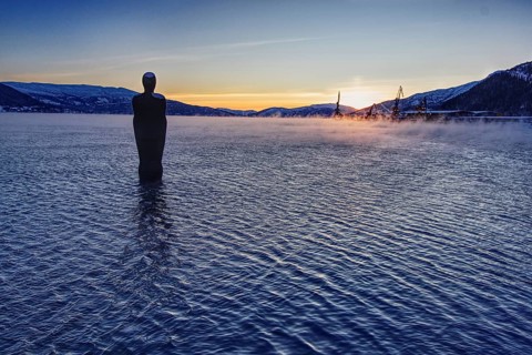 Sunset over a lake with a statue (Havmannen) in the water, Mo i Rana, Norway
