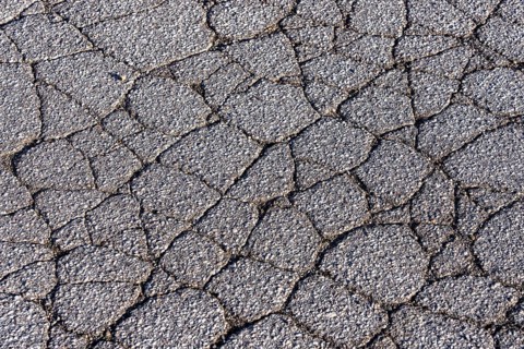 Asphalt surface, floor, with many small cracks, roadway, parking lot
