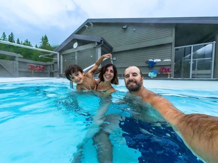 Happy family taking a selfie while bathing in miette hot springs, the hottest natural hot springs