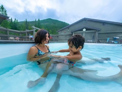 Mother and son are enjoying time together, playing in the warm, soothing waters of miette hot