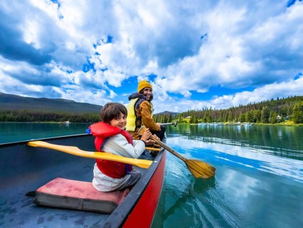 Father and son are paddling a canoe on beautiful maligne lake in jasper national park, alberta,