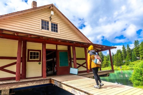 Hiker standing on the wooden pier of the boathouse at maligne lake enjoying the breathtaking view