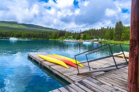 Colorful kayaks lined up on a wooden dock at maligne lake in jasper national park, alberta, while