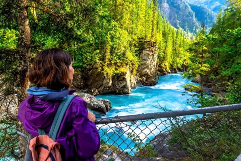 Female hiker enjoying the breathtaking turquoise waters of the fraser river cascading through the