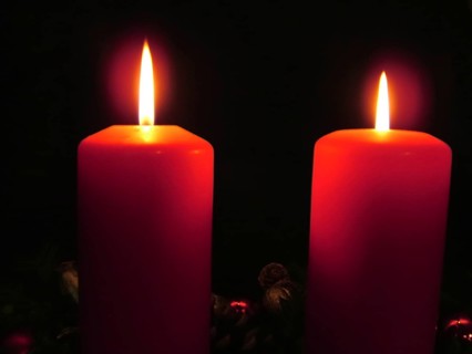 Two burning red candles create a calm and contemplative atmosphere in the dark, Advent wreath with