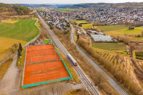 Train line and tennis courts on the outskirts of the city in hilly countryside, historic event,