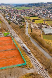 Train travels along tennis courts near a city, historic event, first test run with a passenger