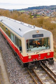 Side view of a moving train on the rails with an urban landscape in the background, historic event,