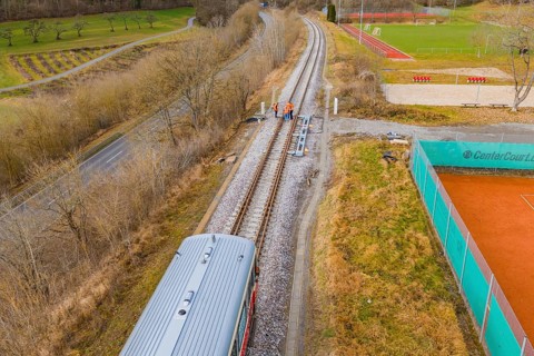 Aerial view of railway tracks next to a sports field with a passing train, historic event, first