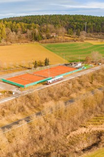 Land view of tennis courts next to a moving track, historic event, first test run with a passenger
