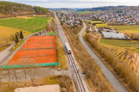 Panorama of a rural area with train next to tennis courts, historic event, first test drive with a