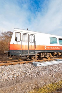 A train on rails under a blue sky with inscriptions visible on the wagons, historic event, first