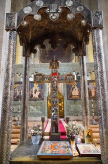 Richly decorated church altar with holy icons and cross surrounded by flowers, Svetitskhoveli
