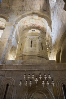 Romanesque church with stone structures and detailed relief decorations in softly lit atmosphere,