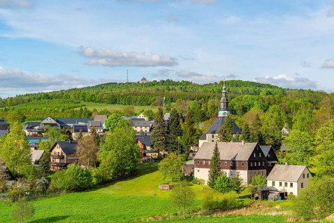 Residential buildings and landmarks of the historic mountain church, in the back forest on