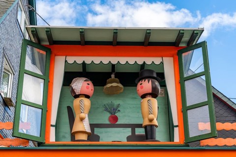 Two large wooden figures of man and woman in a small house, health resort and toy village Seiffen,