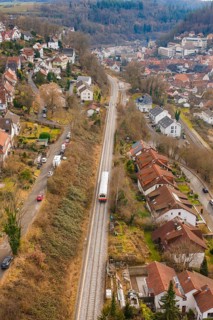 Suburb with railway line through hilly landscape with various residential buildings, historic