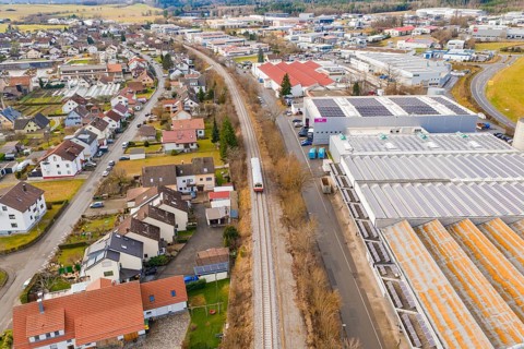 Cityscape with a train traveling through a mix of residential district and industrial area,