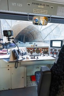 View of a tunnel from the train driver's cab, with technical equipment and control panel in the