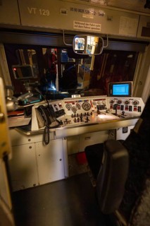 Driver's cab in the dark with illuminated control panel and technical controls, historic event,