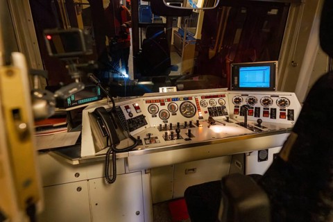 Train driver stand at night, illuminated controls and monitors with an insight into the technology