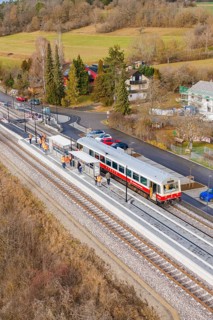 Train at the train station, surrounded by trees and small houses in a wintry landscape, historic