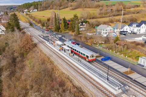 Small train on the platform in a rural area with houses and trees, historic event, first test run