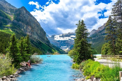 Turquoise water flowing into the stunning lake louise in banff national park, with tourists