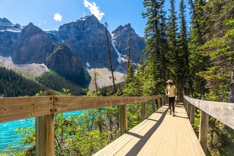 Female tourist walking on the rockpile trail admiring the turquoise color and the majestic