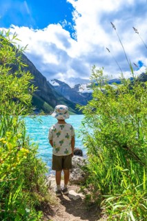Young tourist admiring the stunning turquoise waters of lake louise, framed by victoria glacier and