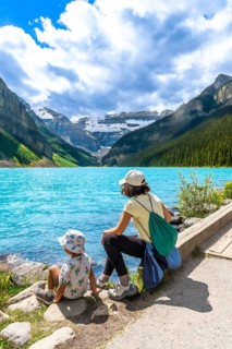 Mother and child are enjoying the breathtaking view of the turquoise waters of lake louise.