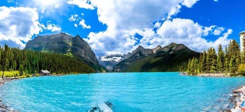 Panoramic view of tourists canoeing on turquoise lake louise, featuring the iconic fairmont chateau
